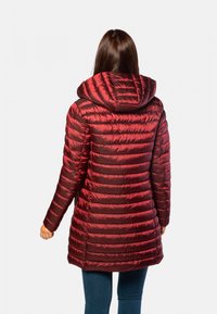 Manteau matelassé rouge avec capuchon, présentant un design rembourré et une texture brillante. Manches longues et longueur genoux, avec des rayures verticales et des coutures sans couture.