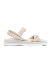 Beige platte sandalen met een geknoopte voorkant, verstelbare bandjes en een dikke witte zool voor comfort. Glad leren textuur.
