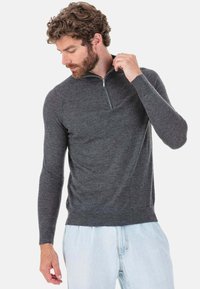 Grauer Pullover mit Viertel-Reißverschluss aus weichem Strickstoff. Verfügt über lange Ärmel, ein leichtes Tragegefühl und eine lockere Passform am Saum und Kragen.