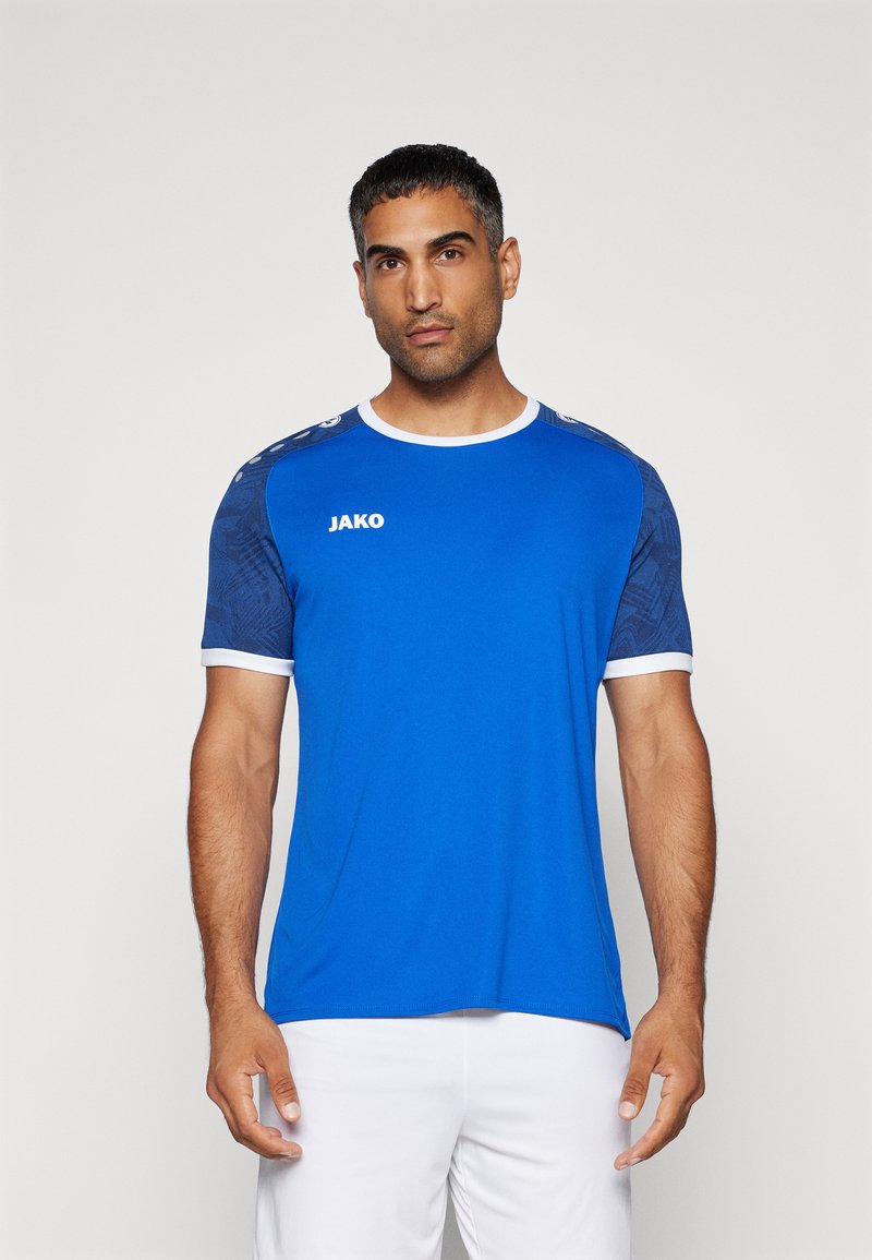 Maglia sportiva blu con accenti bianchi e colletto rotondo. Le maniche corte presentano un tessuto blu a motivi. Logo "JAKO" in bianco sul davanti.