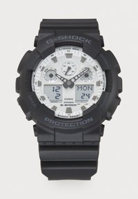 G-SHOCK watch featuring a matte black band and case, white dial with analog and digital displays, and silver accent details. Waterproof design.