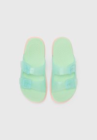 Grønne transparente sandaler med to justerbare stropper, rosa såler og en teksturert fotseng for grep. Lettvekts og vannvennlig design.