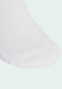 Calzino bianco in cotone con un motivo a maglia testurizzato, punta arrotondata e tallone rinforzato. Finitura liscia senza branding o accenti visibili.