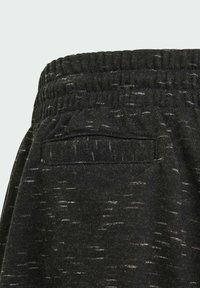 Pantalones deportivos negros de tejido texturizado, con una cintura elástica y un bolsillo trasero para mayor comodidad.