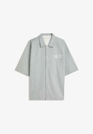 Grijs overhemd met korte mouwen en kraag, voorzien van een gemêleerde stof, knopen aan de voorkant en een wit geborduurd logo aan de linkerkant.