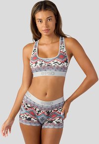 Set sportovní podprsenky a šortek s mnohobarevným geometrickým a zvířecím vzorem, vyrobené z elastického materiálu, s šedým elastickým pasem.