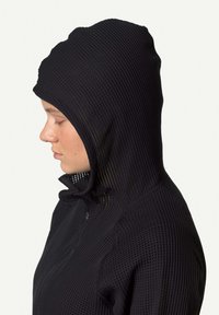 Schwarze Netz-Hoodie mit passgenauem Design, hohem Kragen und einer engen Kapuze, die einen strukturierten Stoff mit kleinen, gleichmäßigen Öffnungen präsentiert.
