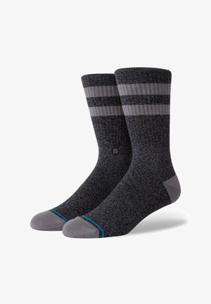 Calcetines gris oscuro con tejido texturizado, que presentan dos franjas horizontales gris claro y un acento turquesa en la punta.