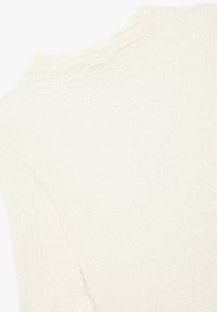 Gestructureerde off-white trui met een subtiel golvend patroon, voorzien van een hoge halslijn en lichte zijsplitten aan de onderzoom.