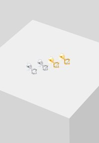 Silberne und goldene Stud-Ohrringe mit runden klaren Edelsteinen, die im minimalistischen Stil entworfen sind. Jedes Paar verfügt über einen einfachen Stecker und eine Rückseite.