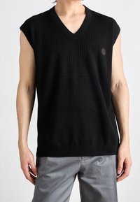 Czarny bezrękawnik z dekoltem w serek, z prążkowaną fakturą na korpusie i małym logo po lewej stronie.