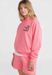 Set di felpa con cappuccio e pantaloni corti di colore rosa brillante, realizzato in tessuto morbido. La felpa presenta una stampa del logo sulla parte anteriore; i pantaloni corti hanno il logo abbinato sulla gamba.