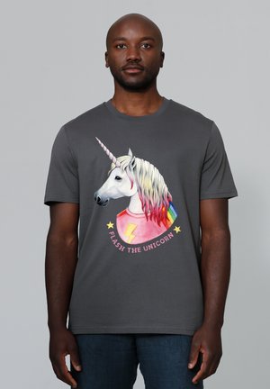 T-shirt en coton gris arborant un graphique de licorne colorée avec une crinière arc-en-ciel et des étoiles, étiquetée "FLASH THE UNICORN" dans un design circulaire.