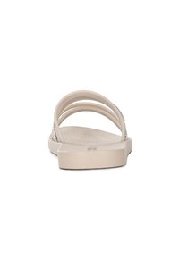 Sandali beige chiaro con tre strap sottili e una suola testurizzata, realizzati in materiale simile alla gomma. Suola piatta con un design semplice.