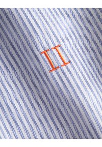 Modré a biele pruhované látky s vyšívaným oranžovým "II" v strede. Štruktúrované tkanie pridáva vizuálny záujem a detail.