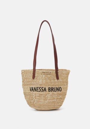Spleciona torba ze słomy z napisem "VANESSA BRUNO", wyposażona w długie brązowe skórzane ramiączka.