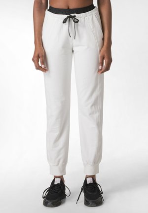 Weiße Sweatpants mit einem schwarzen elastischen Bund und Kordelzug, ausgestattet mit Seitentaschen und gerippten Bündchen an den Knöcheln.