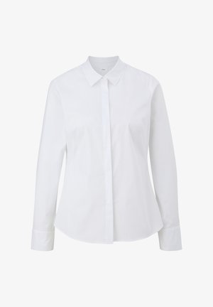 Chemise blanche à manches longues avec col pointu et fermeture à boutons sur le devant. Le tissu semble lisse et a une coupe ajustée, avec un ourlet arrondi.