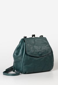 Zaino in pelle verde acqua con forma arrotondata, pattina pieghevole e chiusura a bottone. Presenta una tracolla e una superficie testurizzata.