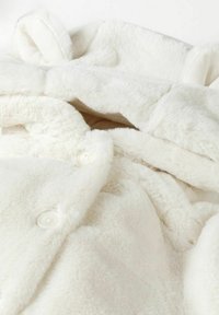 Hoodie bianco in morbido pelliccino sintetico con un design accogliente, caratterizzato da un collo alto, un grande cappuccio e chiusure a bottoni. Trama liscia su tutta la superficie.