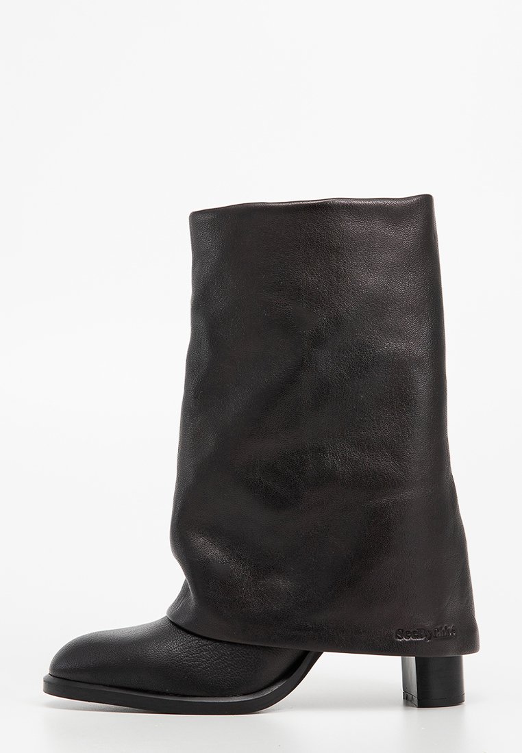 Bottines noires en cuir avec un design supérieur décontracté, un bout arrondi et un talon épais. Présente une texture lisse et un minimum de détails de marque.