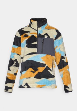 Pull en polaire avec un motif abstrait multicolore comprenant des teintes d'orange, noir, bleu et crème. Dispose d'une poche poitrine zippée en gris.