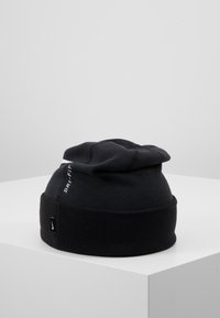 Zwarte beanie muts van zacht materiaal, met een opgevouwen rand en een lichte slouch. Geborduurd 'DRI-FIT' logo aan de zijkant.