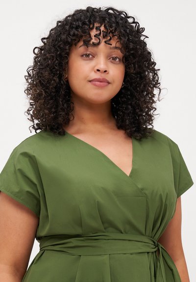 Abito avvolgente verde con maniche corte, scollatura a V e vita con fiocco. Realizzato in tessuto morbido, presenta un design semplice e senza motivi visibili.