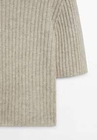 Beige gestrickter Pullover mit kurzen Ärmeln, der ein strukturiertes Muster und einen weichen Stoff aufweist. Die Ränder sind ohne Verzierungen fertiggestellt.