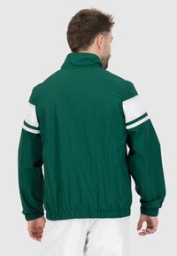 Grüne, leichte Jacke mit hohem Kragen, elastischen Bündchen und weißen Streifen an den Ärmeln. Strukturierter Stoff mit lässigem Schnitt.