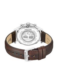 Chronografska ura Timberland s ohišjem iz nerjavnega jekla in rjavim usnjenim trakom s srebrno spono; drevesni logotip na hrbtni strani.