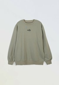 Oliwkowy sweter z długim rękawem i okrągłym dekoltem z małym abstrakcyjnym czarnym wzorem na środku klatki piersiowej, z prążkowanymi mankietami i dołem.