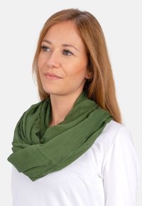 Grüner Schal aus leichtem Material, mit einem weichen, strukturierten Stoff, der um den Hals drapiert ist, mit einem lockeren, fließenden Design.