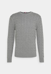 Pull gris tricoté avec texture en câble, col rond, et poignets et ourlet côtelés. Comprend un petit accent de logo sur la manche.