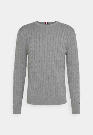 Pull gris tricoté avec texture en câble, col rond, et poignets et ourlet côtelés. Comprend un petit accent de logo sur la manche.