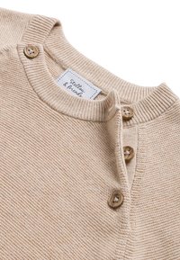 Beige gebreide trui met een ronde hals, drie houten knopen op de sluiting en een textuurafwerking met een label waarop "Stell&Friends" staat.