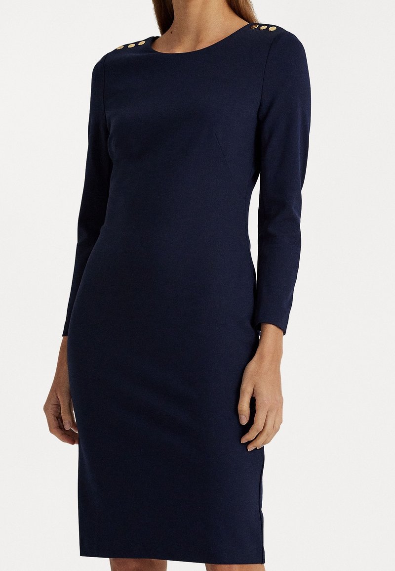 Navy blue fitted dress with long sleeves, round neckline, gold button accents at shoulders, and a smooth, textured fabric.