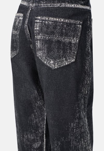 Schwarze Denim-Jeans mit einer ausgewaschenen, abgenutzten Textur. Enthält zwei Gesäßtaschen mit spitzen Klappen und sichtbaren Nähdetails.