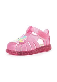 Pink transparent jelly sandals with glitter, open design, and unicorn detail on the front. Adjustable strap for secure fitting.