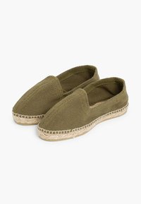 Olijfgroene espadrilles van een gestructureerde geweven stof, met een amandelvormige neus en een jute touwzool. Instapontwerp zonder zichtbare hardware.