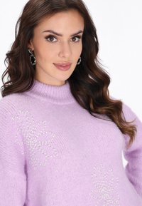 Pulover tricotat lila, cu guler înalt, textură moale și modele florale decorative cu mărgele pe față.