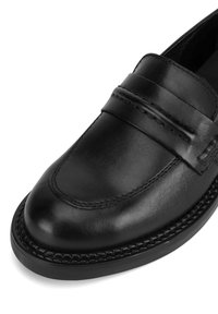 Černé kožené mokasíny s hladkým povrchem, prošívanými detaily a polstrovaným límcem. Podešev je z odolného černého gumového materiálu.