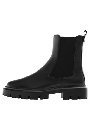 Botte Chelsea en cuir noir avec panneaux latéraux élastiques, semelle épaisse à crampons et languette à l'arrière pour un enfilage facile.