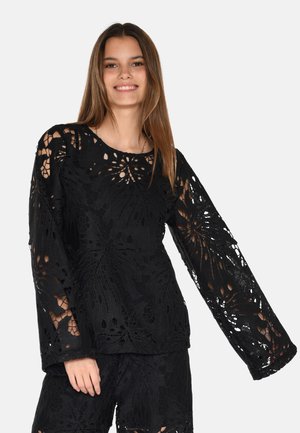Black lace top featuring a floral cutout pattern, long sleeves, and a round neckline. The fabric appears textured and layered.