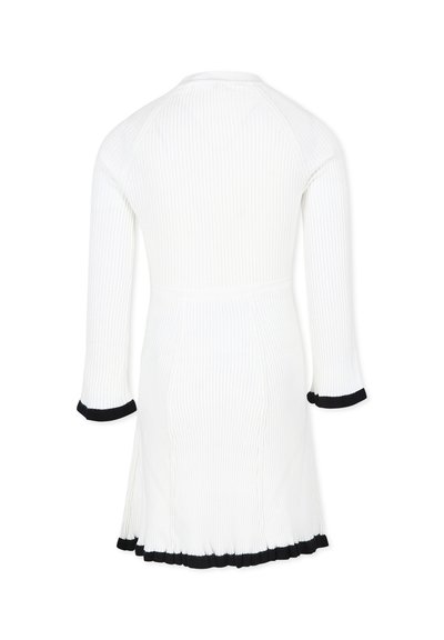Abito bianco a coste con maniche a tre quarti, caratterizzato da finiture nere ai polsini e all'orlo. Design aderente con una gonna svasata.