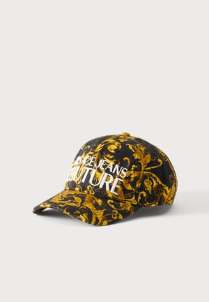 Czarna czapka z ozdobnym żółtym barokowym wzorem kwiatowym i naszytym na przodzie dużymi białymi literami napisem "Versace Jeans Couture".