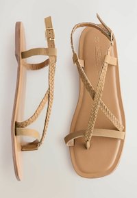 Ruske flate sandaler med flettede stropper, glatt lærinnlegg og rektangulær tåform. Har en spenne for justering.