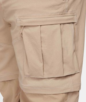 Beige cargobyxor med en stor veckad ficka, sydda detaljer och en slät yta. Fodrad ficka med dragkedja ovanför viken.