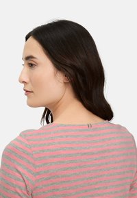 Grau-rosa gestreiftes T-Shirt mit rundem Ausschnitt und einem kleinen Metallakzent auf der Rückseite. Weicher Stoff mit lockerem Schnitt.