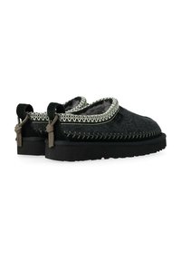 Scarpe slip-on in feltro nero con superficie strutturata, cuciture a contrasto e linguette per facilitare la calzata. Suole spesse in gomma con battistrada per una buona aderenza.